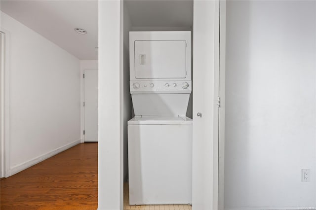 washroom featuring hardwood / wood-style floors and stacked washer / drying machine