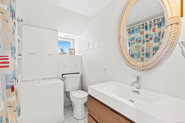 bathroom with tile patterned flooring, vanity, toilet, and lofted ceiling