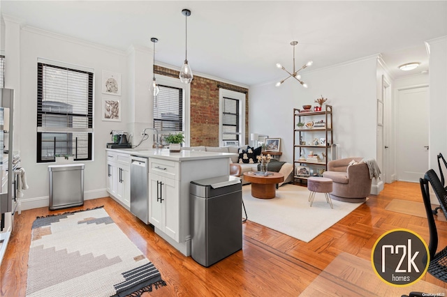 kitchen featuring dishwasher, crown molding, white cabinetry, and hanging light fixtures