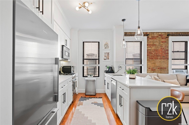 kitchen with brick wall, appliances with stainless steel finishes, light hardwood / wood-style floors, white cabinets, and ornamental molding