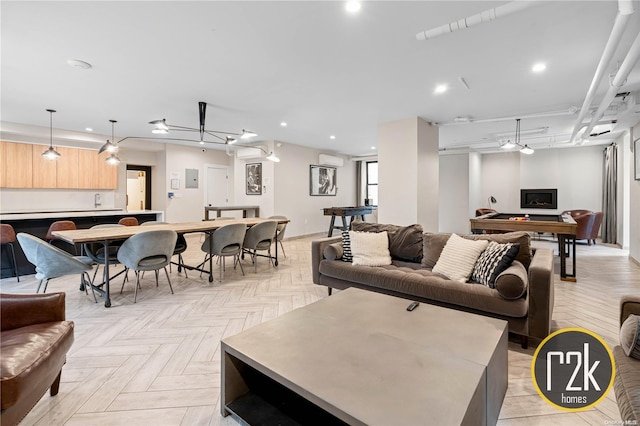 living room with a wall mounted AC, billiards, and light parquet flooring