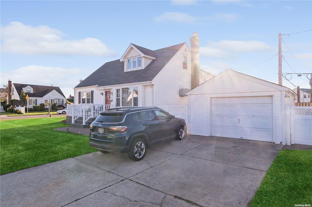 new england style home with an outbuilding, a front lawn, and a garage