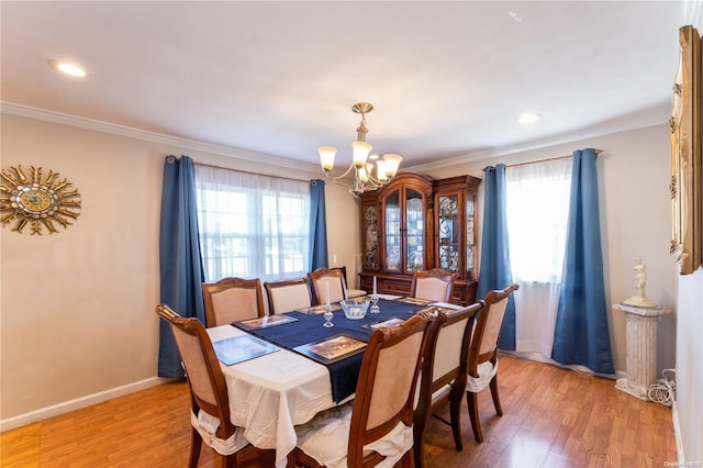 dining space with hardwood / wood-style flooring, a notable chandelier, and crown molding