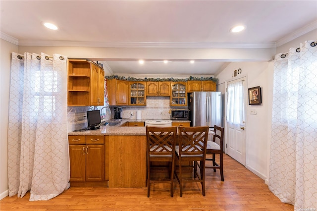 kitchen with appliances with stainless steel finishes, light hardwood / wood-style floors, and crown molding