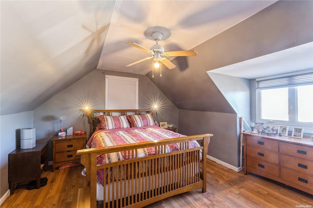 bedroom with ceiling fan, lofted ceiling, and light hardwood / wood-style flooring