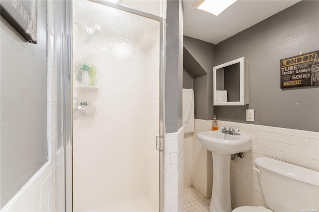 bathroom with an enclosed shower, tile patterned floors, toilet, and tile walls