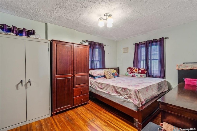 bedroom with light hardwood / wood-style flooring and a textured ceiling