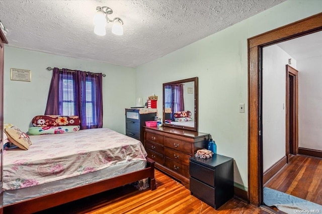 bedroom featuring a textured ceiling and hardwood / wood-style flooring