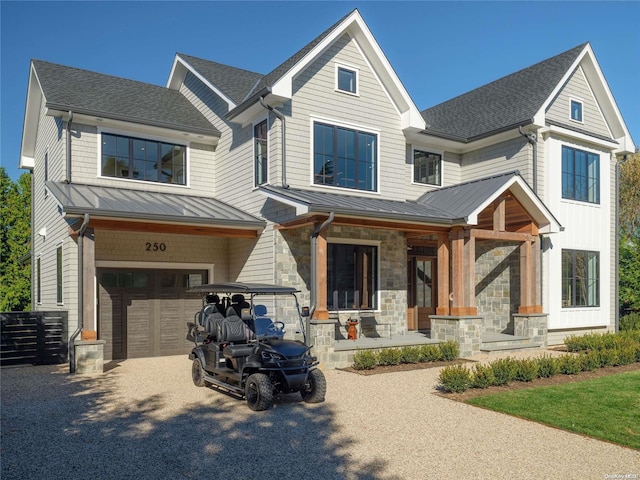 view of front of home with a standing seam roof, covered porch, a garage, aphalt driveway, and metal roof