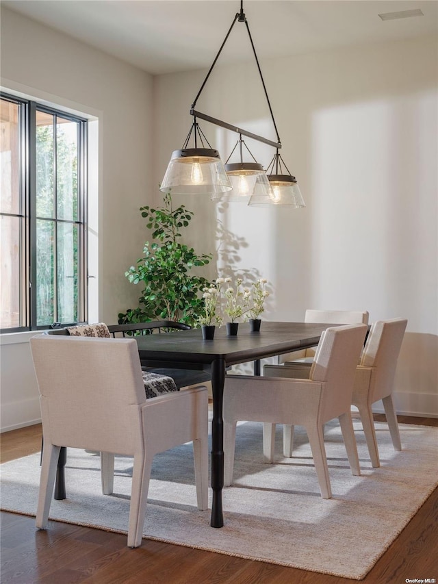 dining space with visible vents, baseboards, and wood finished floors