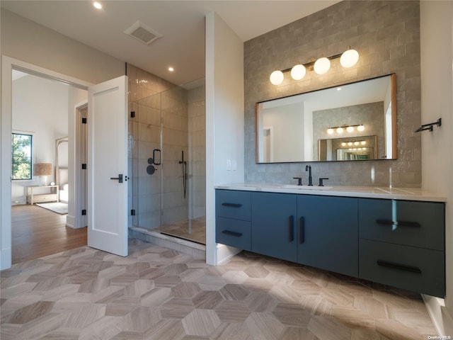 bathroom featuring backsplash, visible vents, a shower stall, and vanity