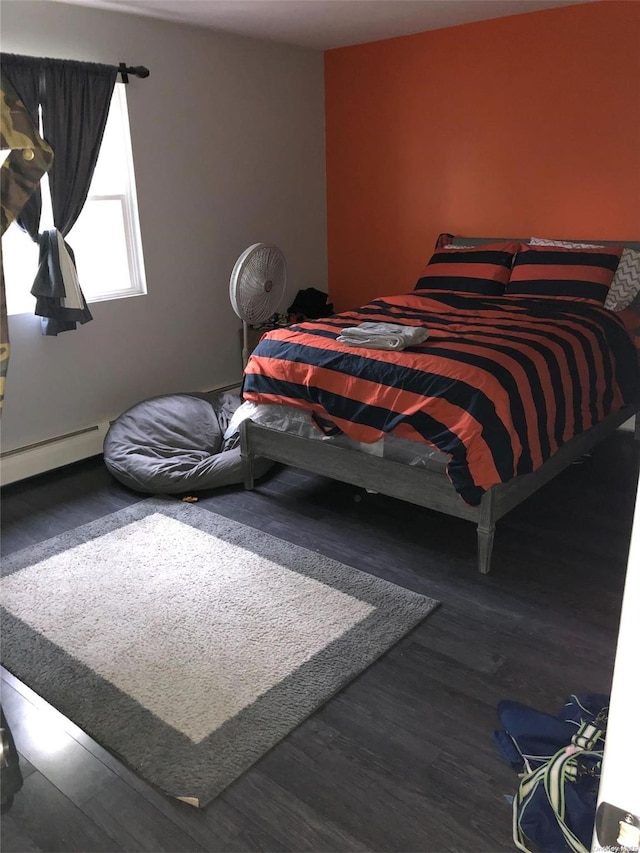 bedroom with hardwood / wood-style flooring and baseboard heating