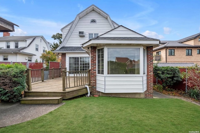 rear view of property with a lawn and a wooden deck