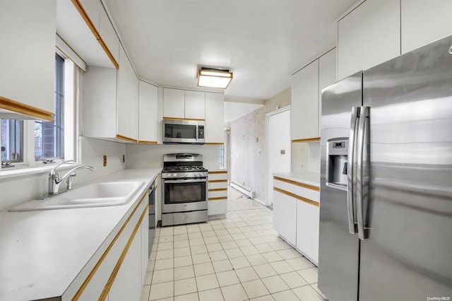 kitchen featuring sink, white cabinets, stainless steel appliances, and light tile patterned floors