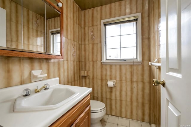 bathroom featuring tile patterned floors, vanity, tile walls, and toilet