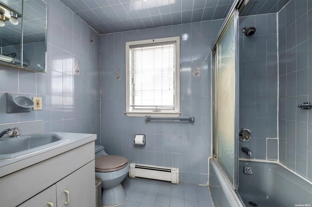 full bathroom with tile patterned floors, vanity, baseboard heating, tile walls, and enclosed tub / shower combo