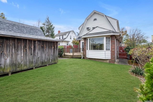 back of property with a wooden deck and a yard