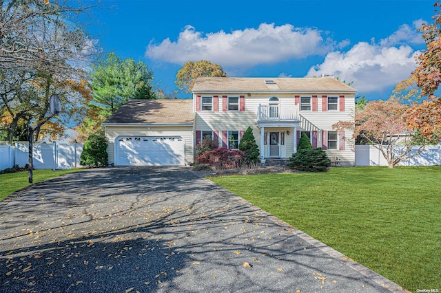 view of front of home with a garage, a balcony, and a front lawn