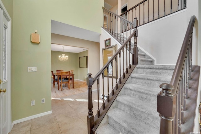 stairway with hardwood / wood-style flooring and a notable chandelier