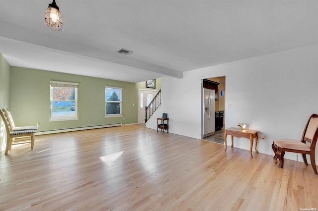 unfurnished room featuring light wood-type flooring and baseboard heating