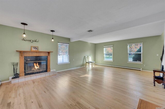 unfurnished living room with a fireplace, light hardwood / wood-style floors, and baseboard heating