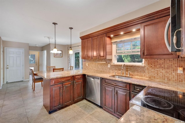 kitchen with kitchen peninsula, stainless steel appliances, a healthy amount of sunlight, sink, and decorative light fixtures