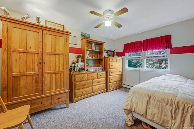 carpeted bedroom with ceiling fan and a baseboard radiator