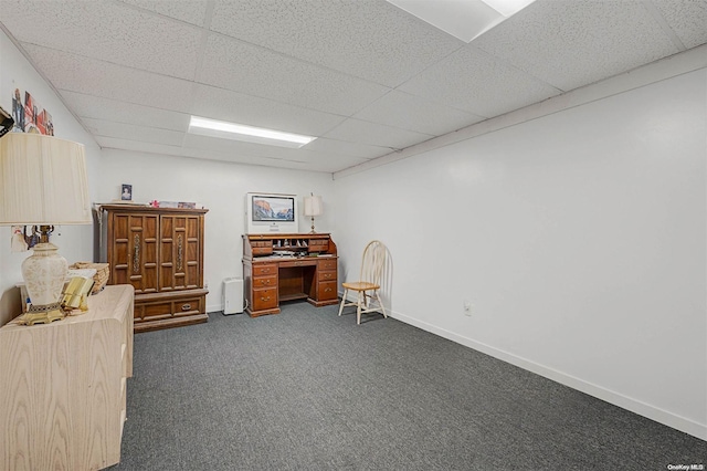 interior space with a paneled ceiling and dark carpet