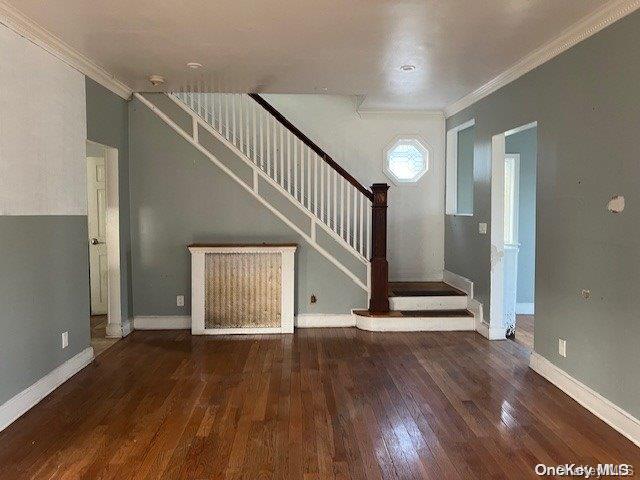 interior space with crown molding and dark wood-type flooring