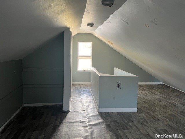 bonus room featuring vaulted ceiling and dark hardwood / wood-style floors