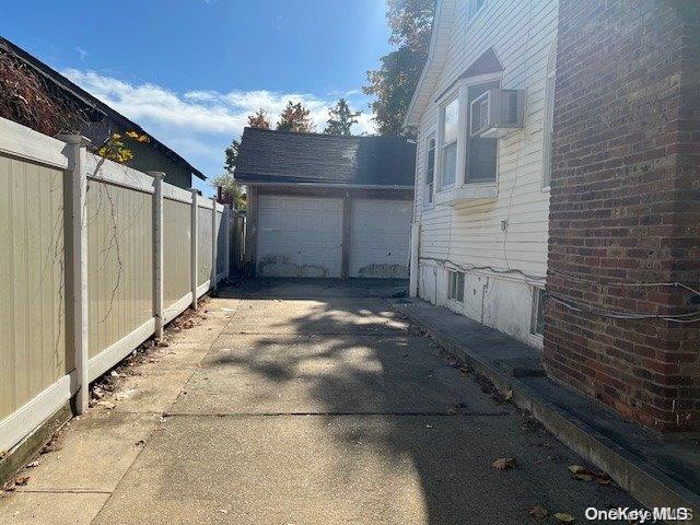 view of side of home featuring a garage and an outdoor structure