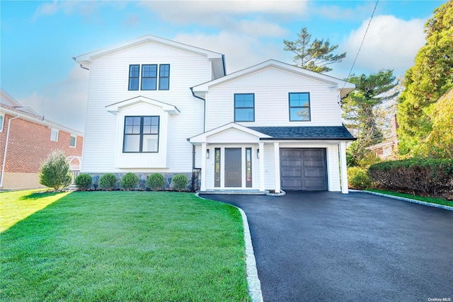 view of front of house with a front yard and a garage