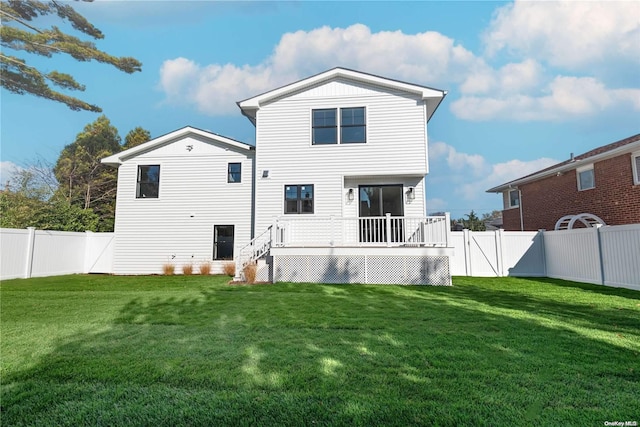 rear view of property with a yard and a deck