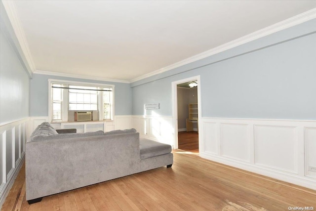 living room with cooling unit, light hardwood / wood-style floors, and ornamental molding