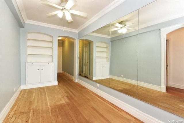 bathroom with wood-type flooring, built in features, ceiling fan, and crown molding