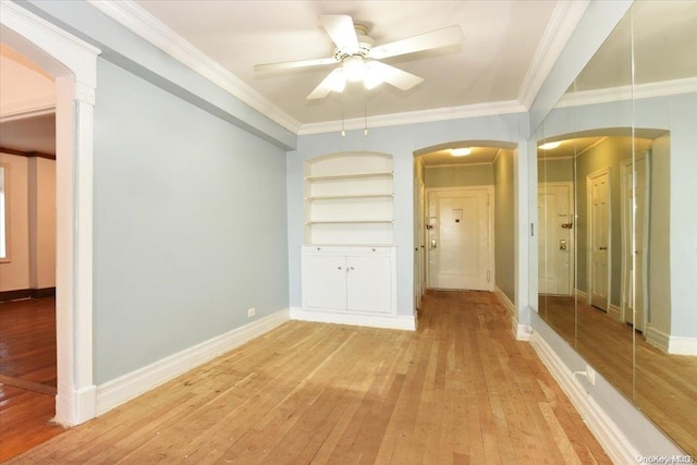 interior space with light hardwood / wood-style floors, built in features, and ornamental molding