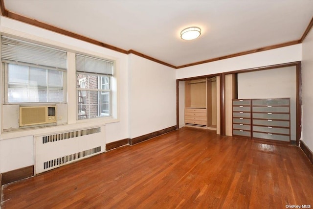 unfurnished bedroom with a closet, radiator heating unit, ornamental molding, and hardwood / wood-style flooring