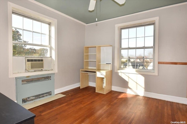 unfurnished office featuring dark hardwood / wood-style floors, cooling unit, crown molding, and radiator