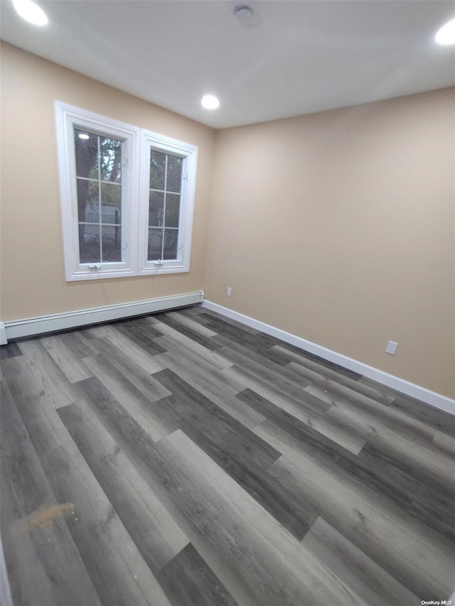 spare room featuring dark hardwood / wood-style floors and baseboard heating