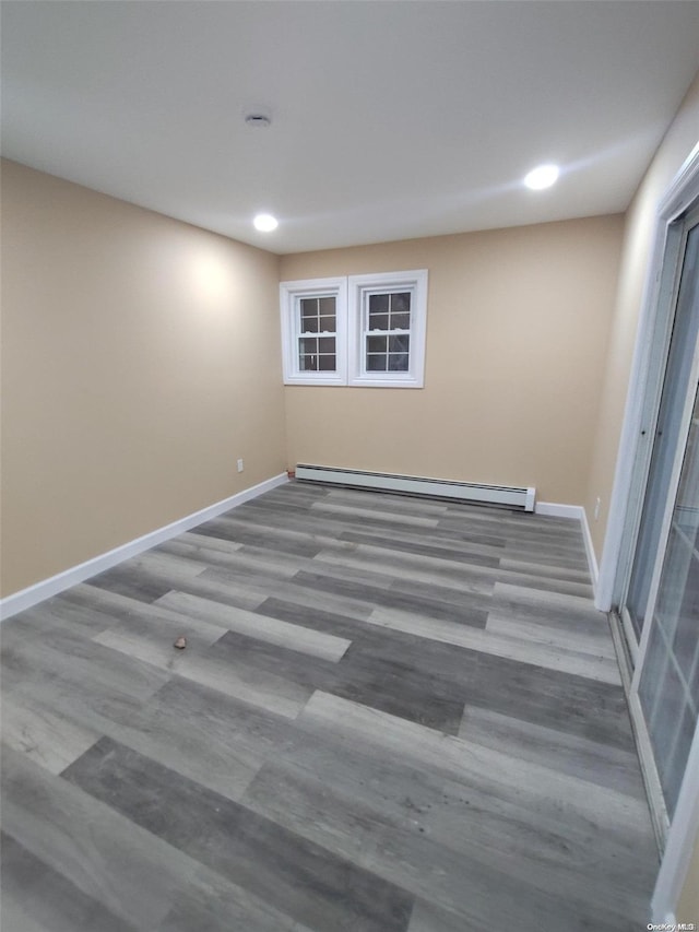 spare room with hardwood / wood-style floors and baseboard heating