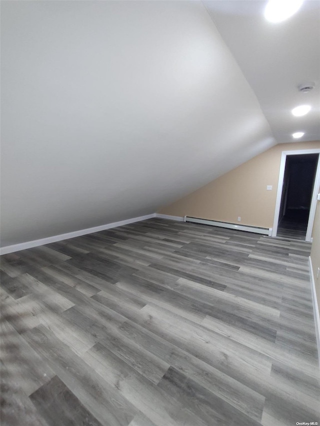 bonus room with wood-type flooring, a baseboard radiator, and vaulted ceiling