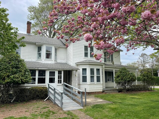 2055 Boisseau Ave, Southold, NY 11971 - view of front of home with a front lawn, roof with shingles, and a chimney