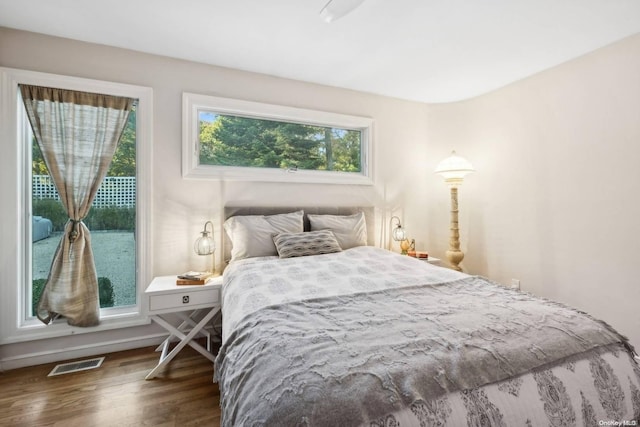 bedroom with hardwood / wood-style floors and access to outside