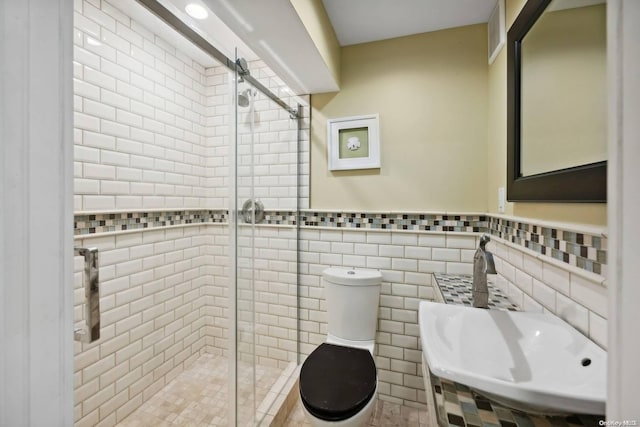 bathroom featuring walk in shower, tile walls, and toilet