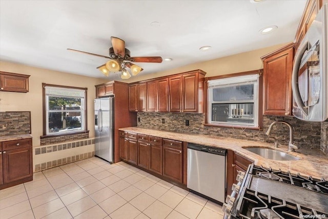 kitchen featuring radiator, sink, ceiling fan, light tile patterned floors, and stainless steel appliances