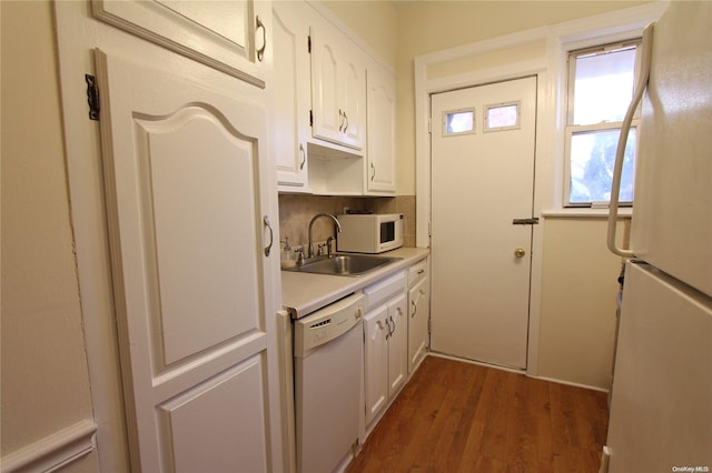 kitchen featuring white appliances, sink, dark hardwood / wood-style floors, decorative backsplash, and white cabinetry