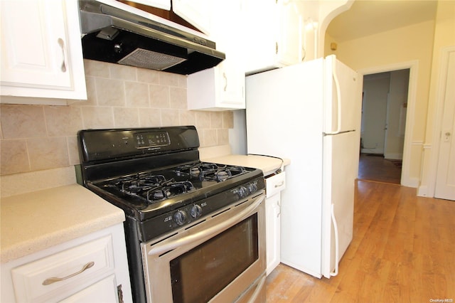 kitchen featuring gas stove, white cabinetry, tasteful backsplash, light hardwood / wood-style flooring, and white fridge