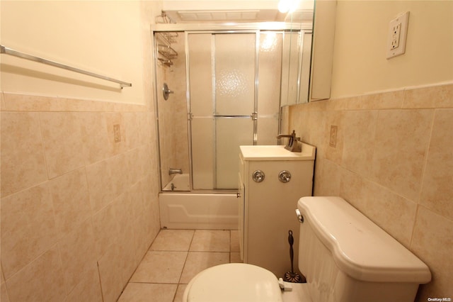 full bathroom featuring tile patterned floors, toilet, tile walls, and combined bath / shower with glass door