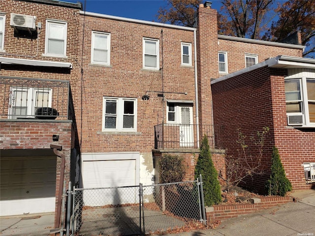 view of building exterior featuring an AC wall unit and a garage