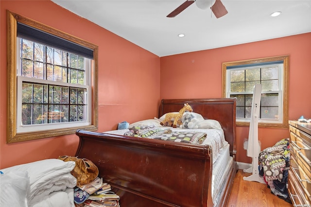 bedroom with multiple windows, ceiling fan, and light hardwood / wood-style flooring